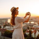 Travel in Europe. Young woman enjoys sunrise. The concept of travel, tourism, vacation and freedom.